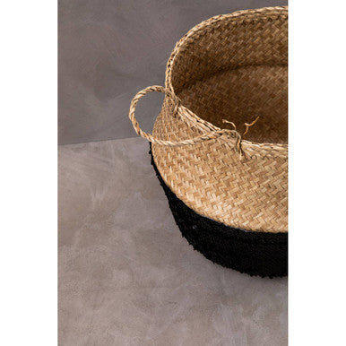 Handwoven natural medium seagrass basket with black base and two looped handles for stylish storage