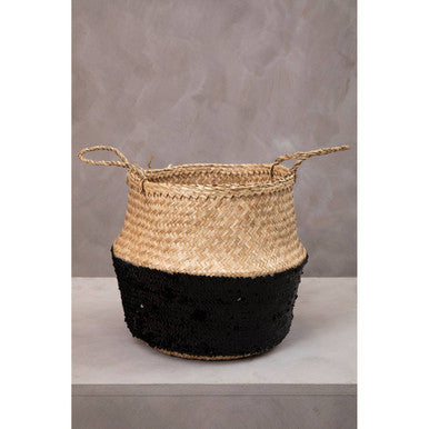 A natural medium seagrass basket with beige top, black bottom, and handles perfect for stylish storage
