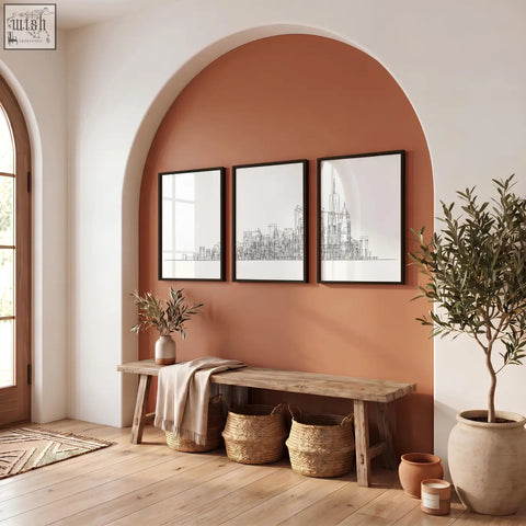 Three panels of black and white canvas new york skyline line art prints hang on a warm terracotta wall