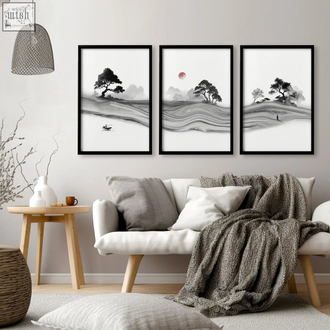Three framed black and white ink landscape prints with a red moon above a white sofa in living room decor