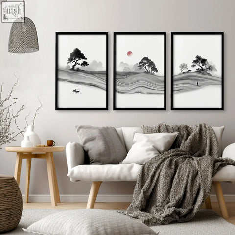 Three framed black and white ink landscape prints with a red moon above a white sofa in living room decor