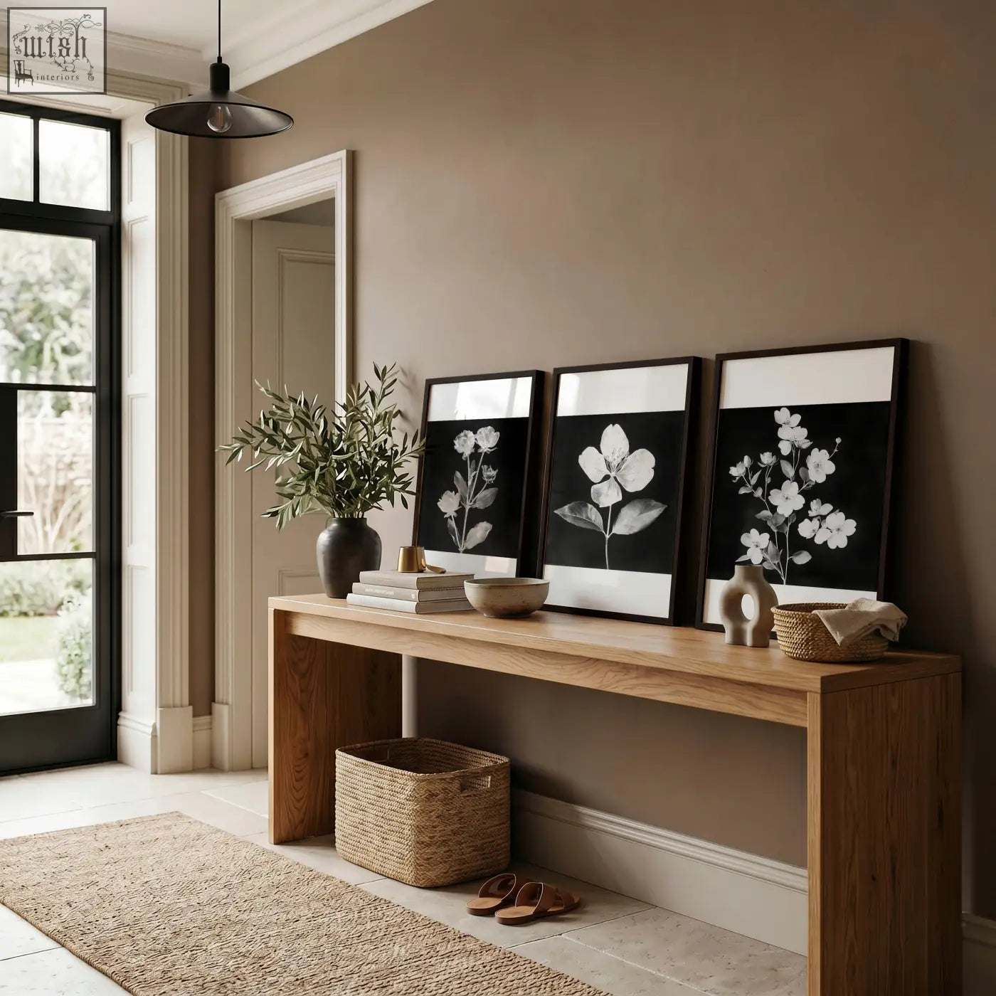 Three black framed pictures with french country botanical prints in minimalist frames on a wooden console table