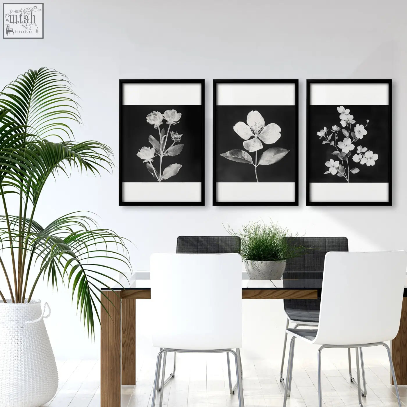 Three black-framed french country botanical wall art prints hang above a dining room table in black and white