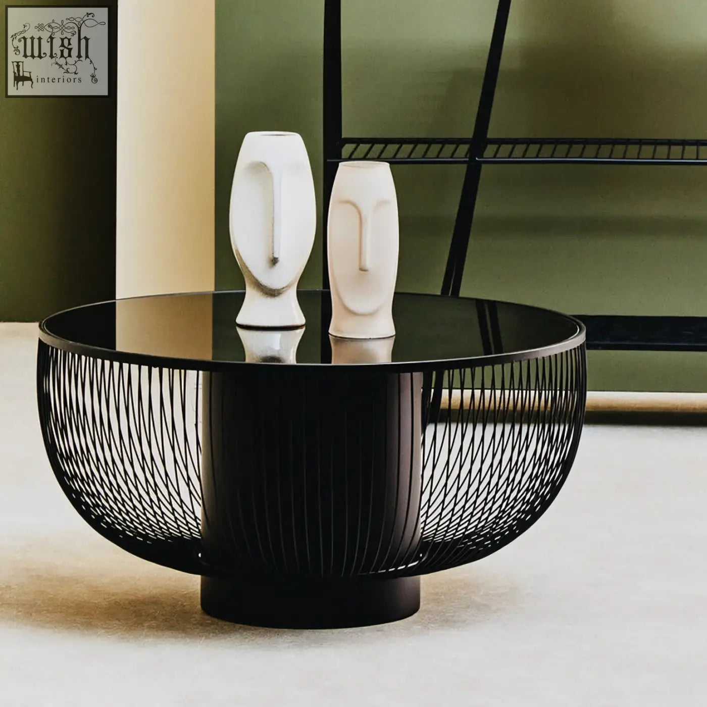 Black glass trento coffee table with matte black wireframe base and glossy top holding two white ceramic face vases