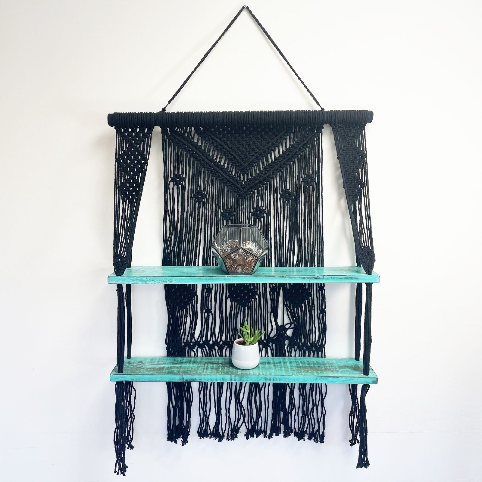 Black macrame hanging shelves featuring turquoise wooden shelves perfect for stylish home decor and storage