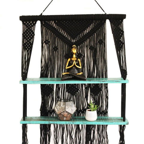 Black macrame hanging shelves with turquoise shelves holding golden buddha statue and plants perfect gift idea