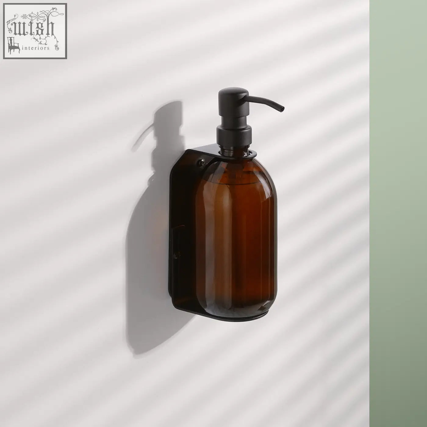 Black single wall mounted soap dispenser with brown amber refillable glass bottle and matte black stainless steel pump