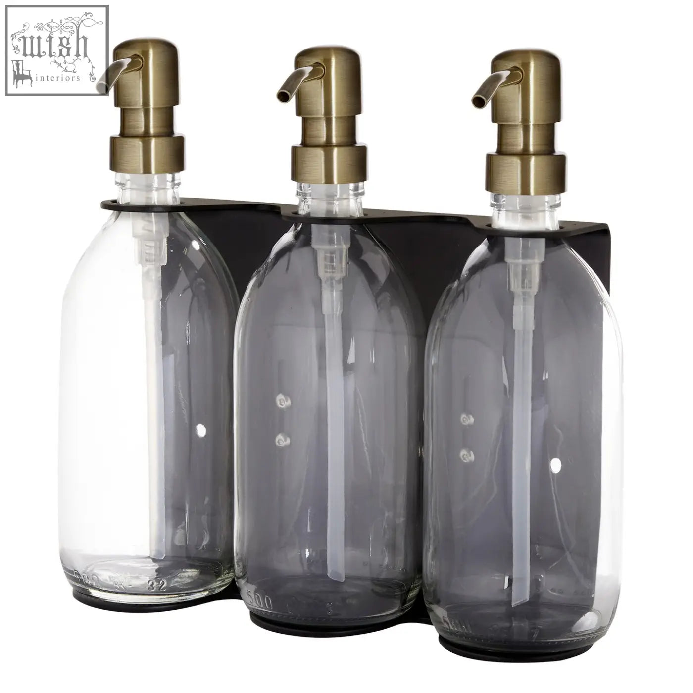 Black triple wall-mounted soap dispenser with three clear glass bottles and brass-tone pumps on a black tray