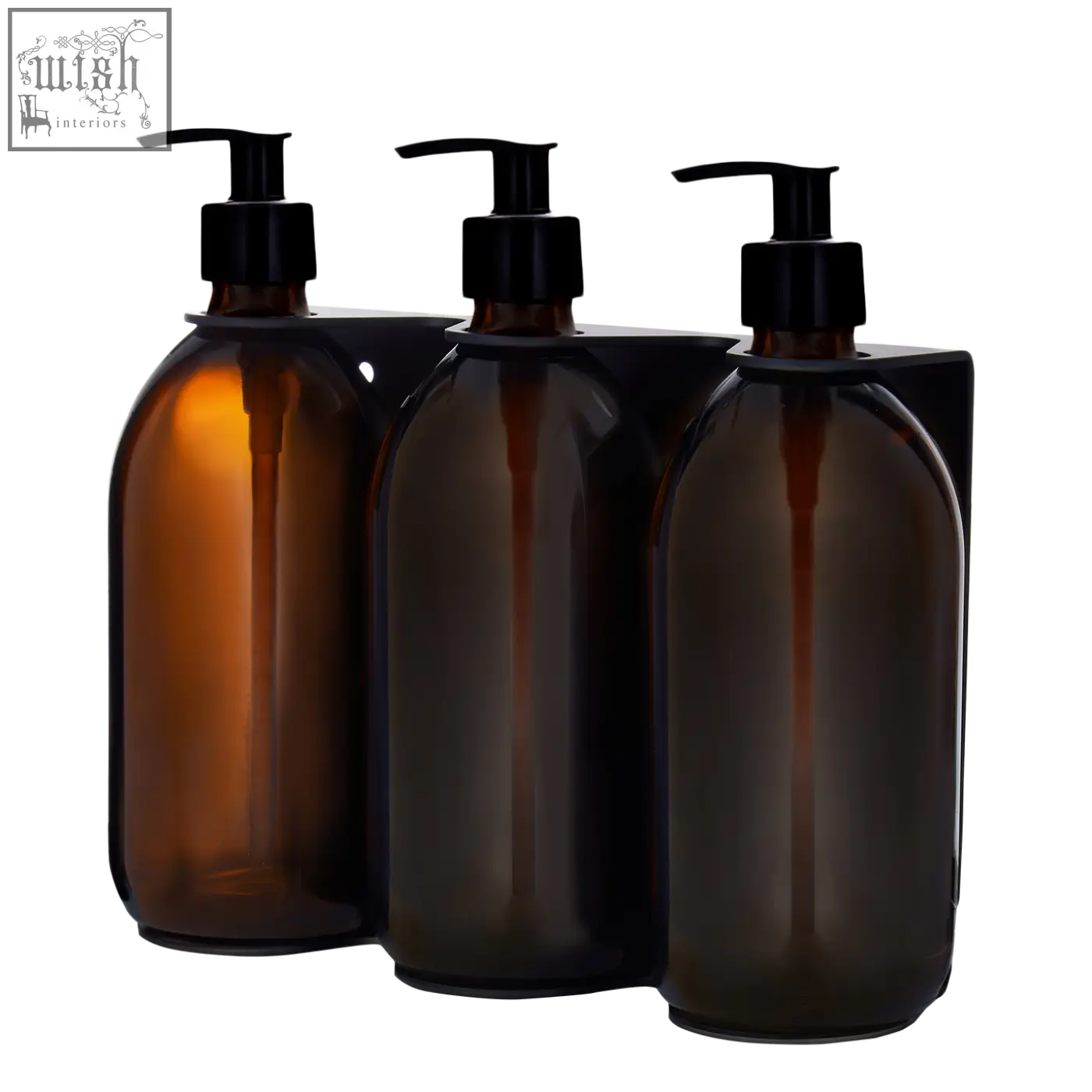 Three amber glass bottles with black pumps in a wall-mounted soap dispenser for black triple use