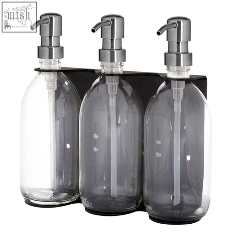 Black triple wall mounted soap dispenser set with sleek transparent glass bottles and brushed stainless steel pumps