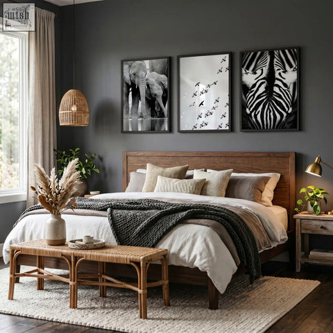 Dark gray wooden bed with woven rattan bench and neutral pillows below black white photography prints of african wildlife wall art set of 3
