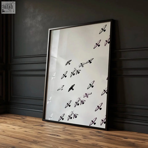 Black framed art print with minimalist black white photography of birds in flight against a light background