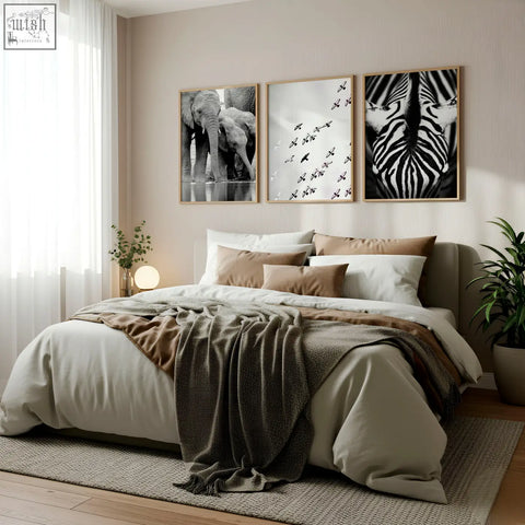 Three framed black white photography prints of african wildlife hang above the bed as wall art set of 3