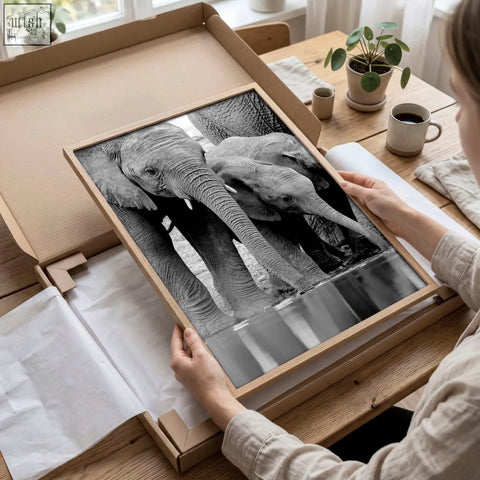 A framed black white photography print of two elephants in a light wood frame from african wildlife wall art set