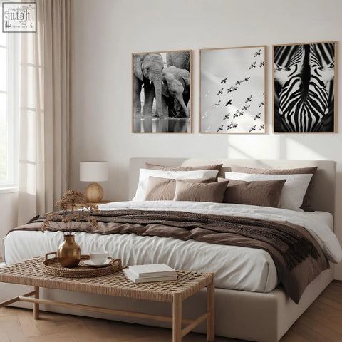 Beige upholstered bed with layered brown and white bedding in black white photography prints set of 3 wall art