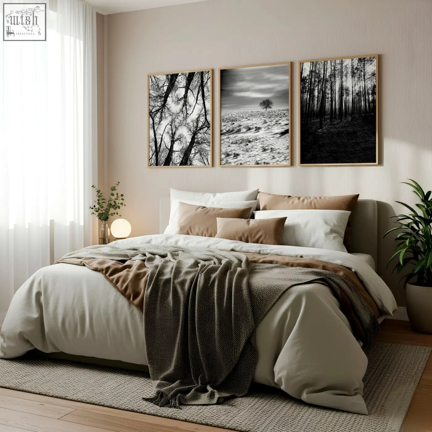 A cozy bed with soft beige and brown linens and a gray throw blanket next to black white photography prints set of 3