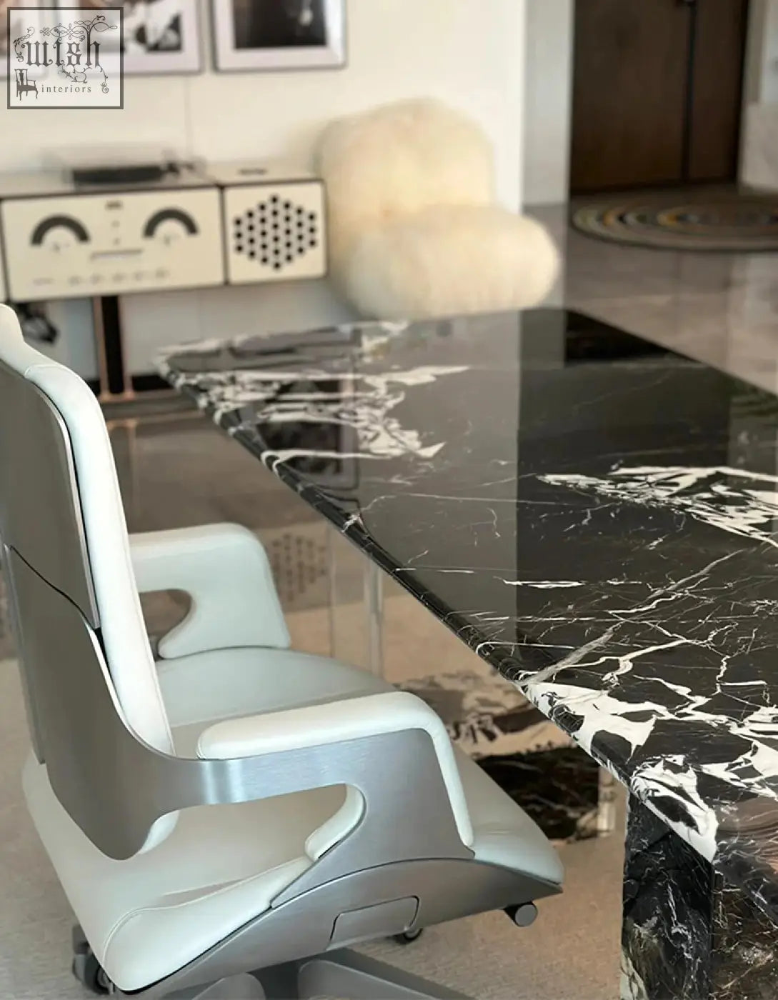 A sleek office chair with silver metal frame and white leather upholstery paired with blanchard office desk art deco style