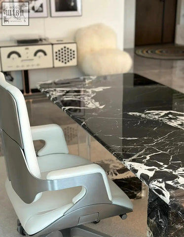 A sleek office chair with silver metal frame and white leather upholstery paired with blanchard office desk art deco style