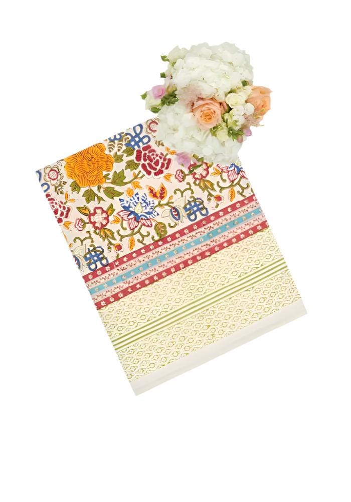 A vibrant blooming spring fabric napkin with intricate floral and geometric designs in bright orange red blue and green tones