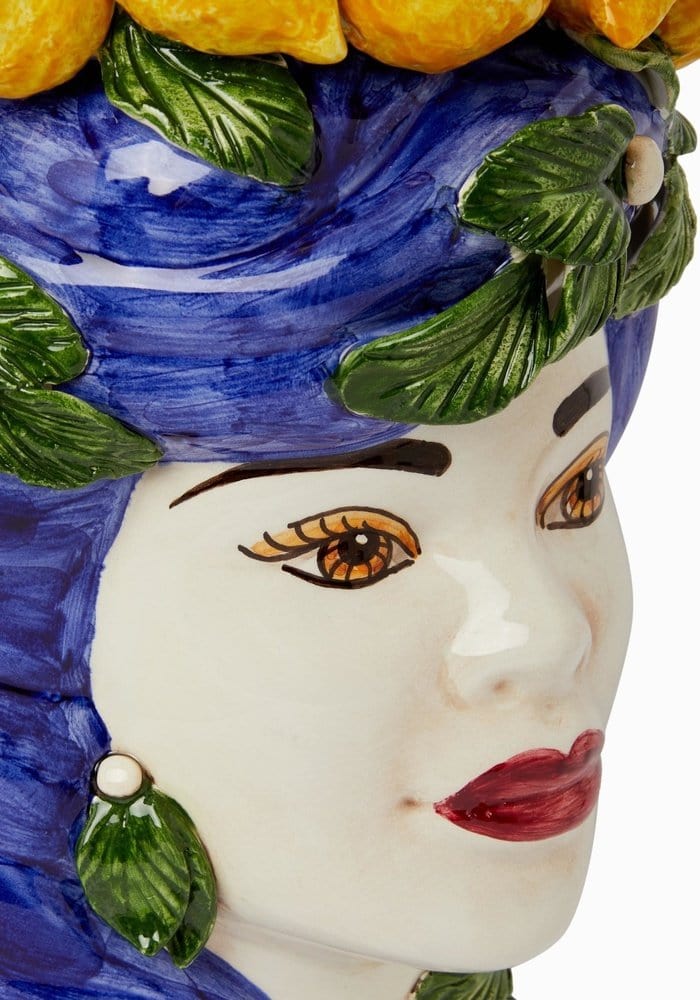 A ceramic bust statue called blu lemon featuring a woman with painted face and blue headpiece with green leaves and lemons