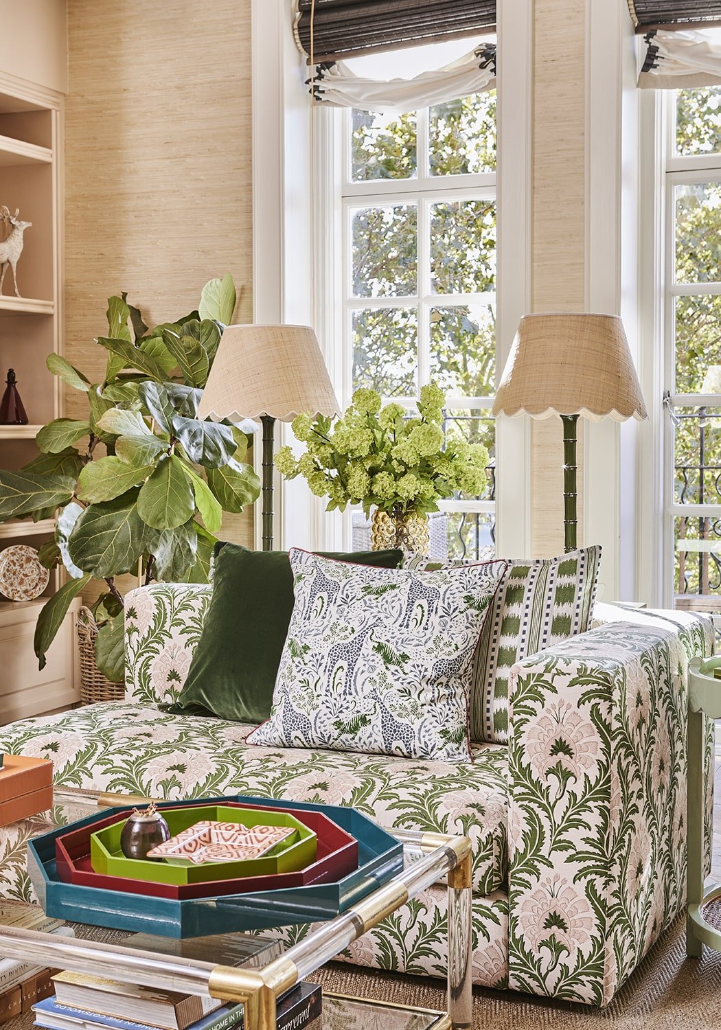Green and cream floral sofa with velvet pillows next to a blue and green stripe cushion cover for decor use