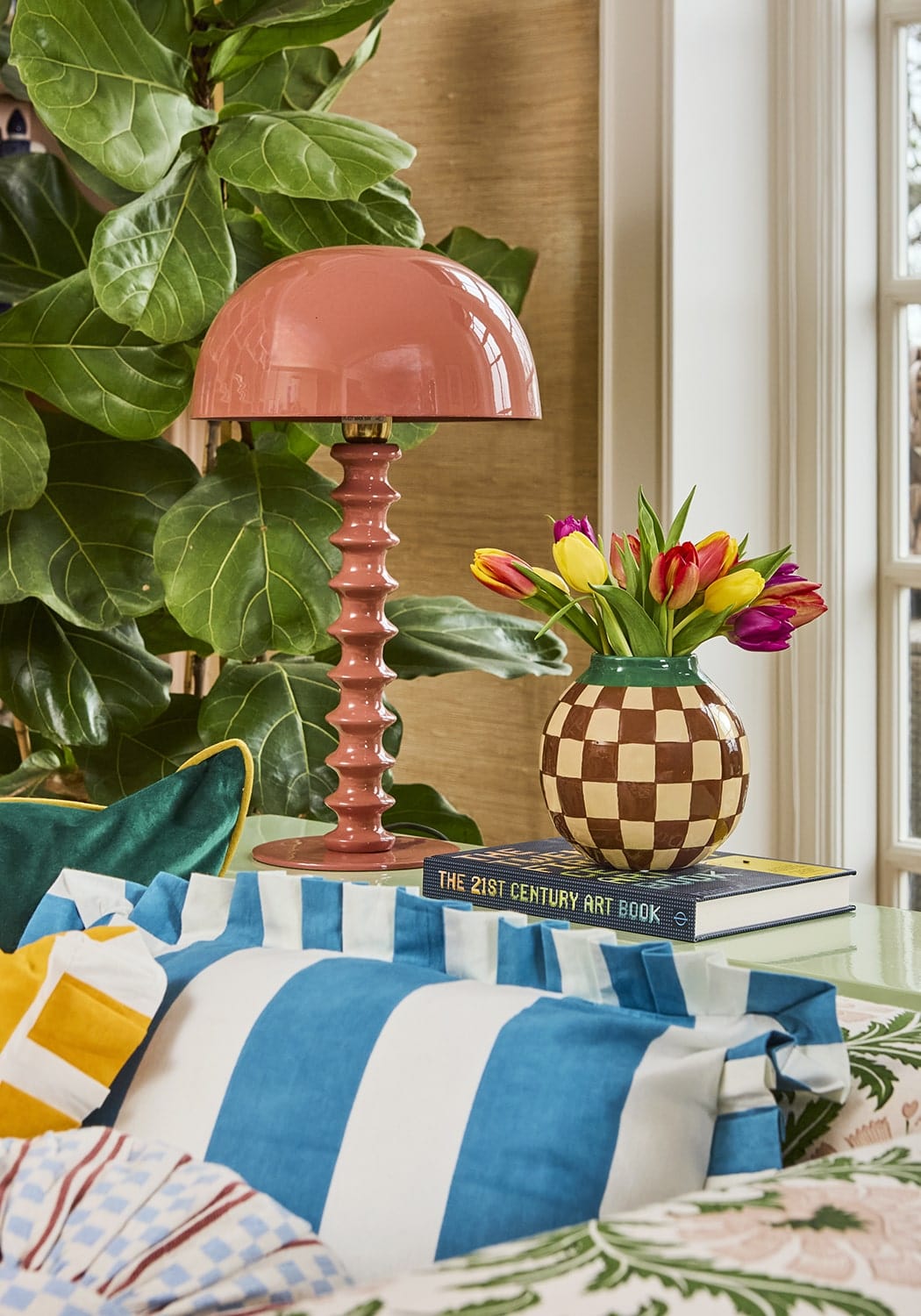 Blue and white cabana striped ruffled cushion cover with a glossy coral pink mushroom shaped table lamp with textured base