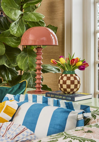 Blue and white cabana striped ruffled cushion cover with a glossy coral pink mushroom shaped table lamp with textured base