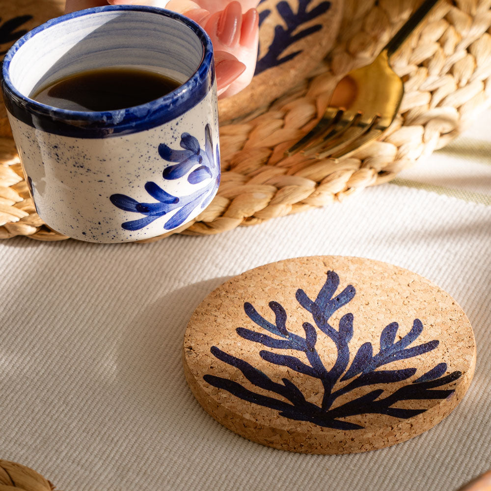 A round heat resistant cork coaster with a navy blue coral design made from portuguese cork
