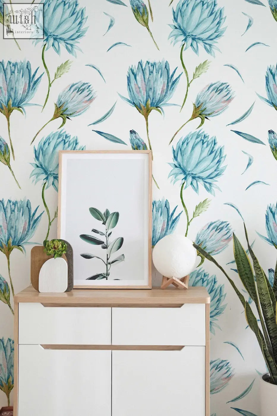Minimalist white-framed botanical print with green leaf illustration on peel and stick wallpaper for living space decor