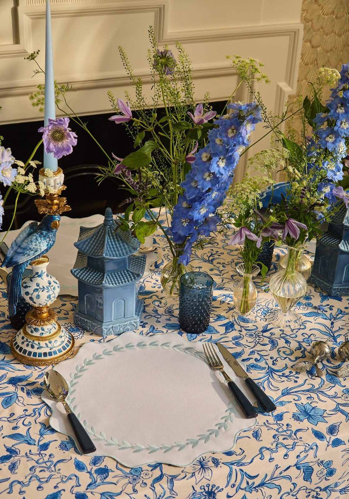Blue ceramic pagoda centerpiece with intricate detailing and glossy finish complements blue garland placemats set of 4