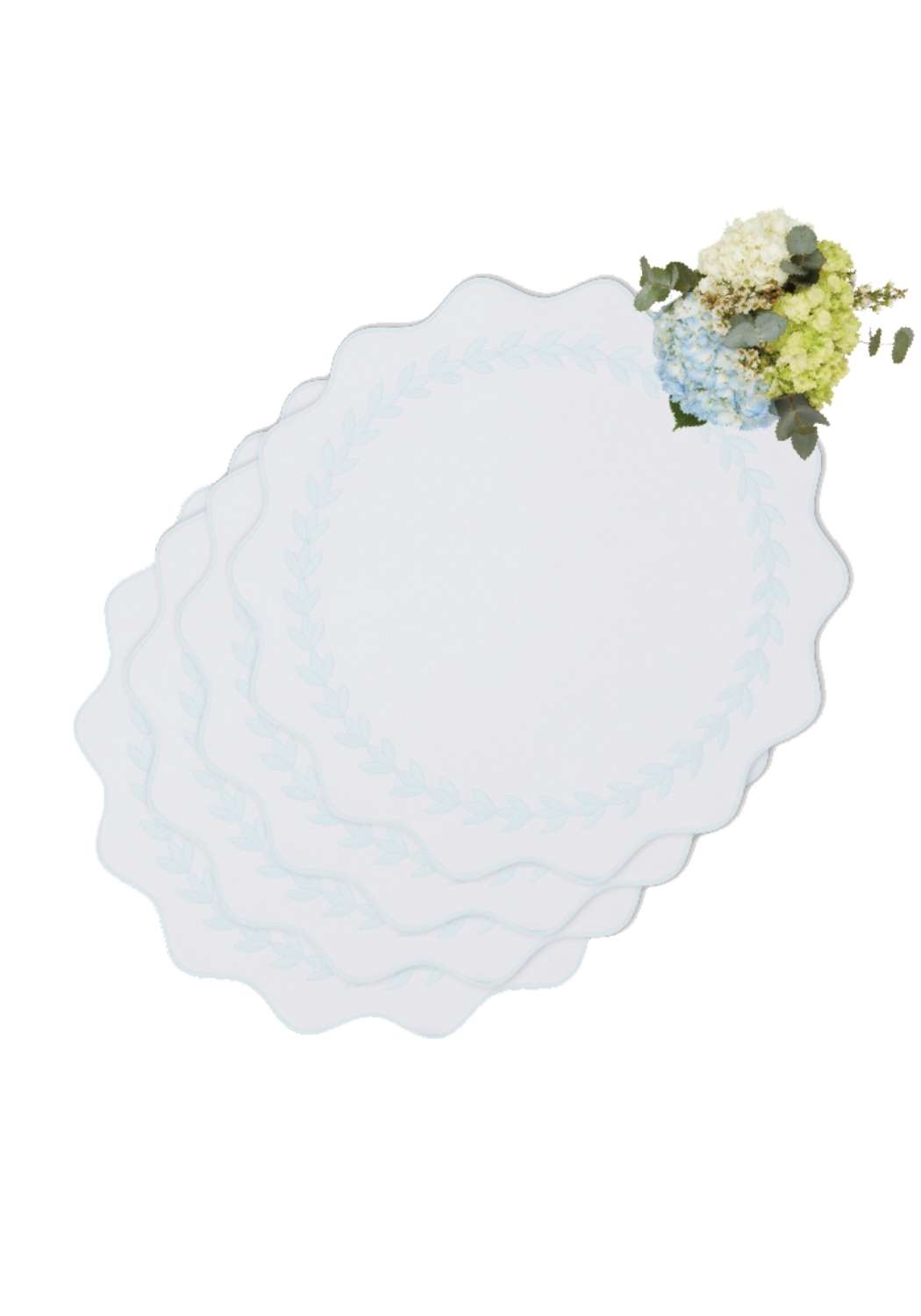 Set of four pale blue garland placemats with scalloped edges and delicate floral corner arrangement for dining table
