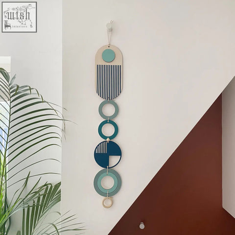 A modern wall art with layered teal, navy, and natural wood geometric shapes for minimal home decor