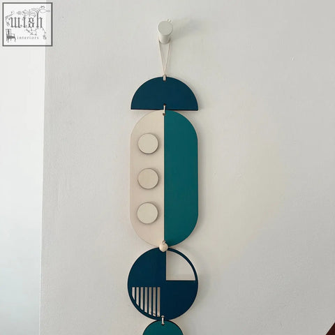 Modern wall art featuring layered teal cream and dark blue geometric wood shapes with minimalist cutouts for home decor