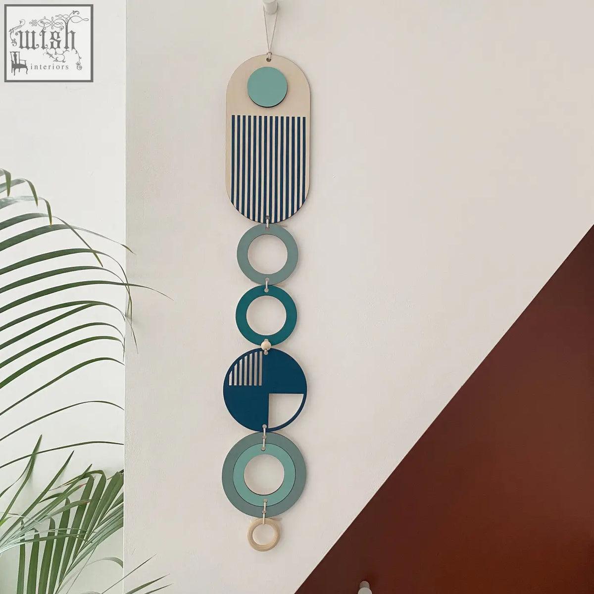 Modern wall art featuring layered teal navy and beige geometric shapes with striped patterns on slim wood panel