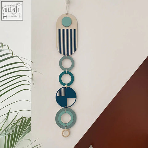 Modern wall art featuring layered teal navy and beige geometric shapes with striped patterns on slim wood panel