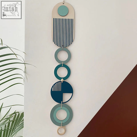 A modern wall art with layered teal navy blue and natural wood geometric shapes perfect for minimal home decor