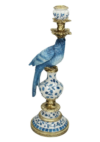 Blue porcelain parrot perched on a tall decorative ceramic candle holder with gold accents and floral patterns