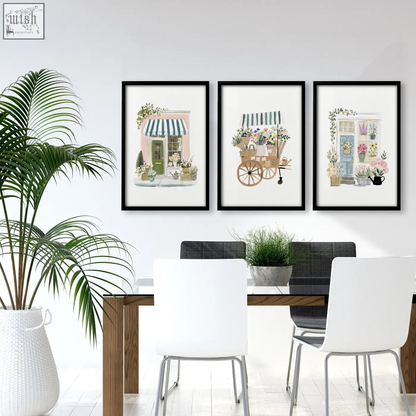 Three blue framed floral shop prints hang as wall art above a dining room table for a flower shop vibe