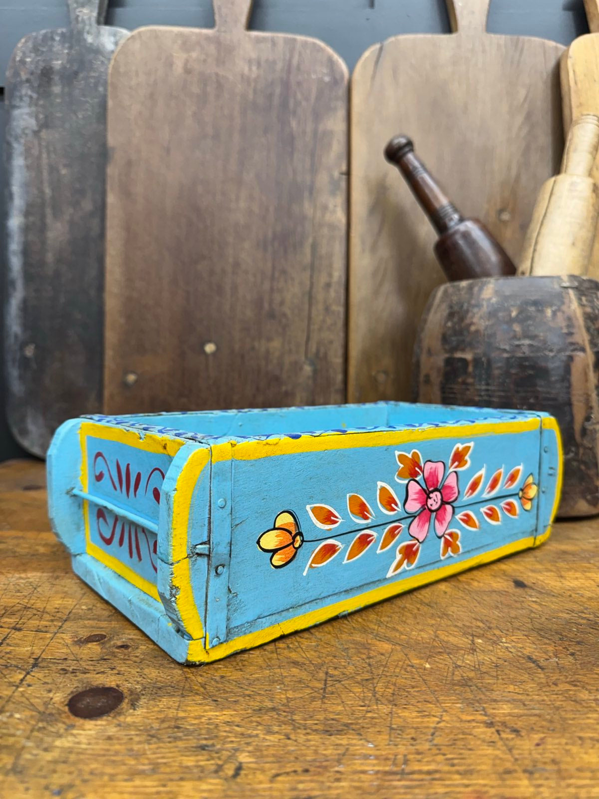 Hand-painted blue wooden brick mould with turquoise exterior yellow trim and colorful floral motifs for herbs or storage