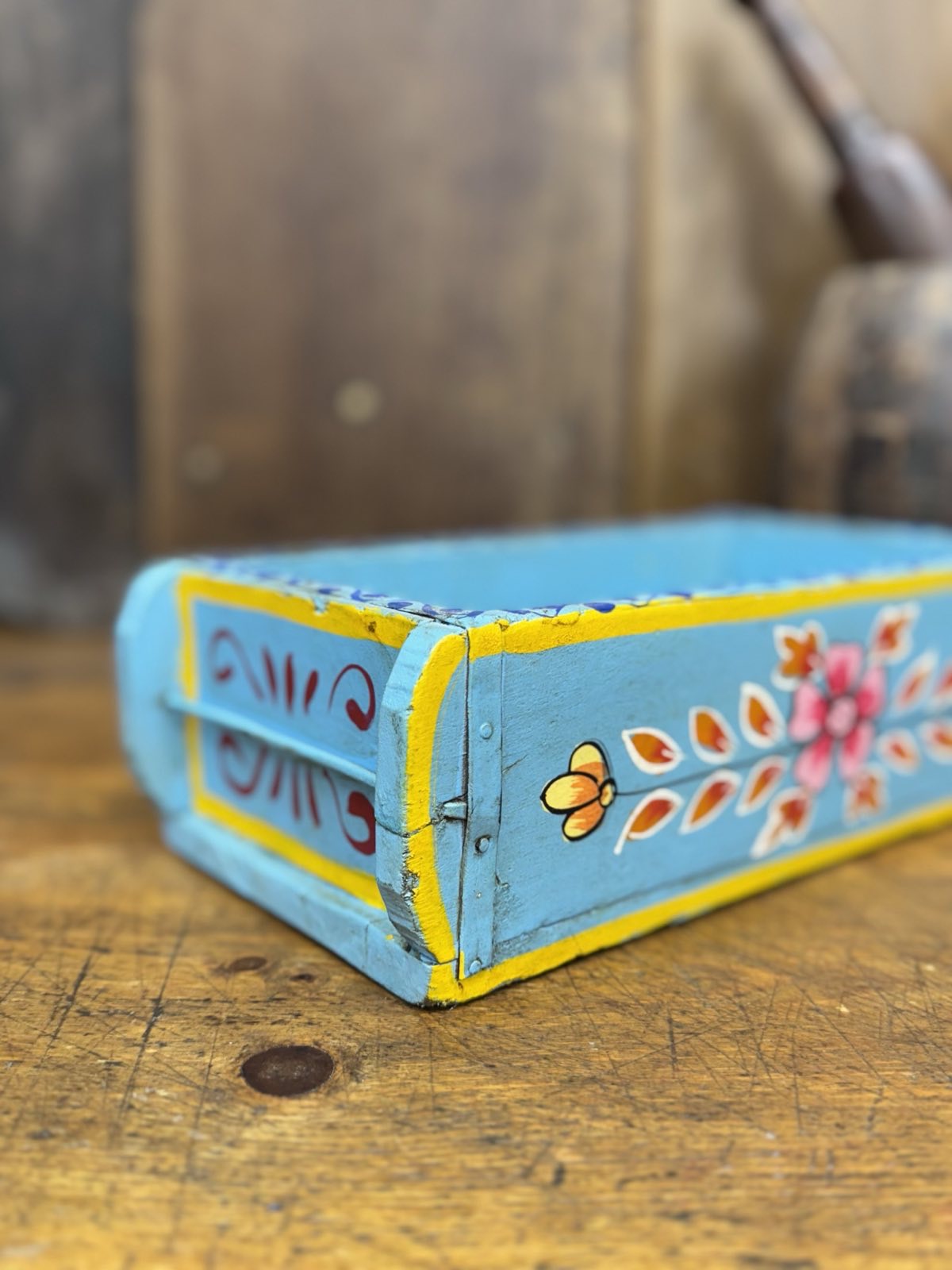 Blue wooden painted brick mould tray with light blue base yellow trim and colorful floral motif for herbs or storage