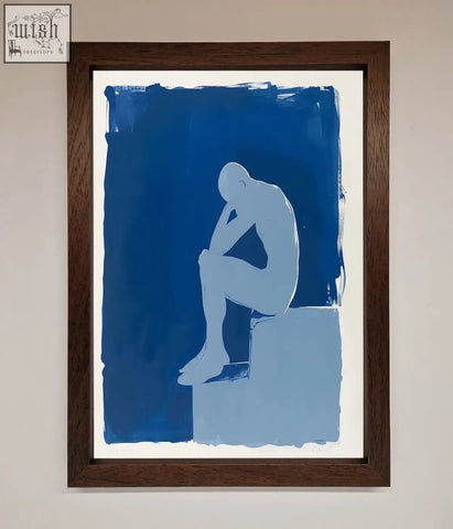 A blues thinking framed print featuring a minimalist white silhouette on blue brushstrokes in a dark wood frame