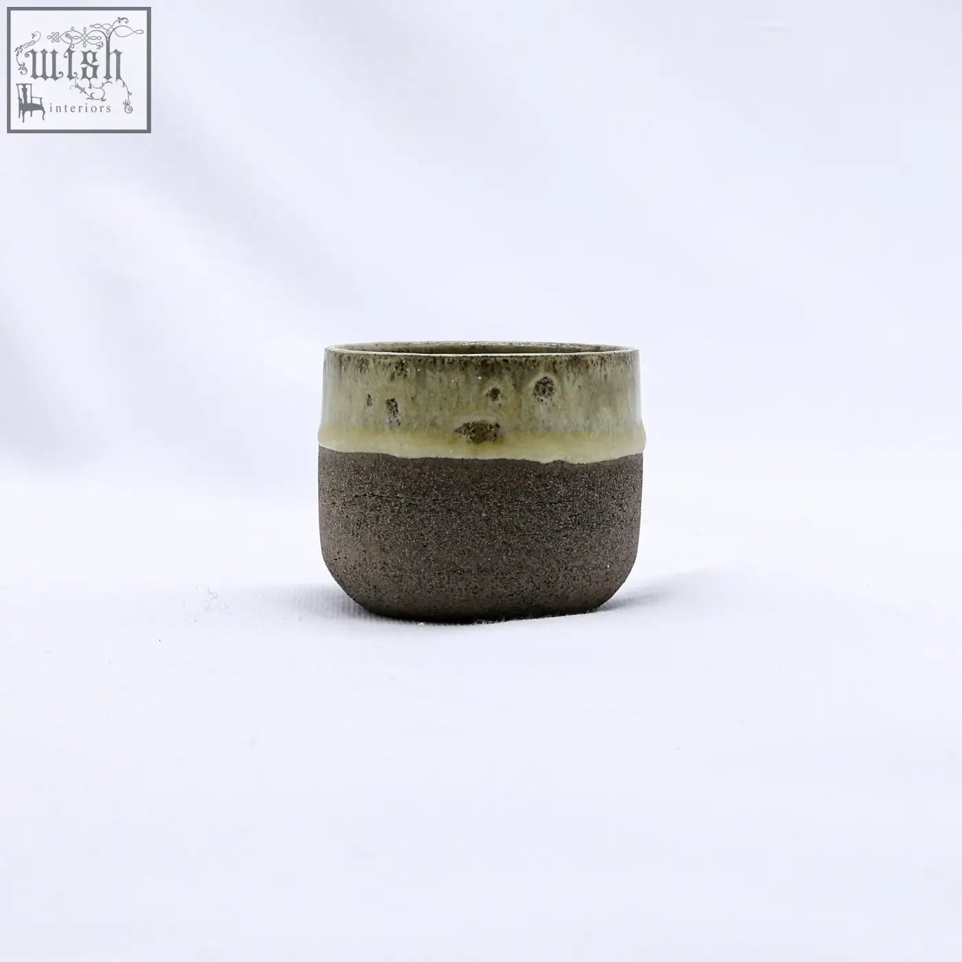 A bluverde picollo grey handmade ceramic espresso mug with a matte dark brown body and speckled olive green rim