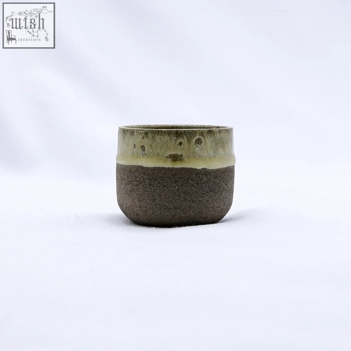 A bluverde picollo grey handmade ceramic espresso mug with a matte dark brown body and speckled olive green rim