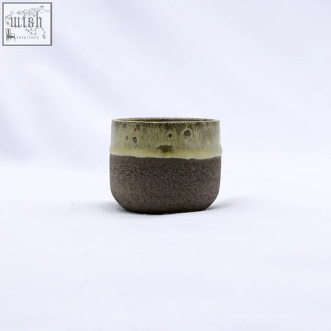 A bluverde picollo grey handmade ceramic espresso mug with a matte dark brown body and speckled olive green rim