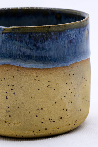 Bluvia goccia handmade ceramic mug with speckled tan stoneware body and glossy blue glaze on the rim