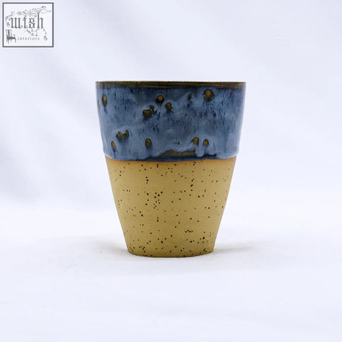 A bluvio quadra stoneware ceramic mug with a speckled tan bottom and textured blue top with golden-brown dots