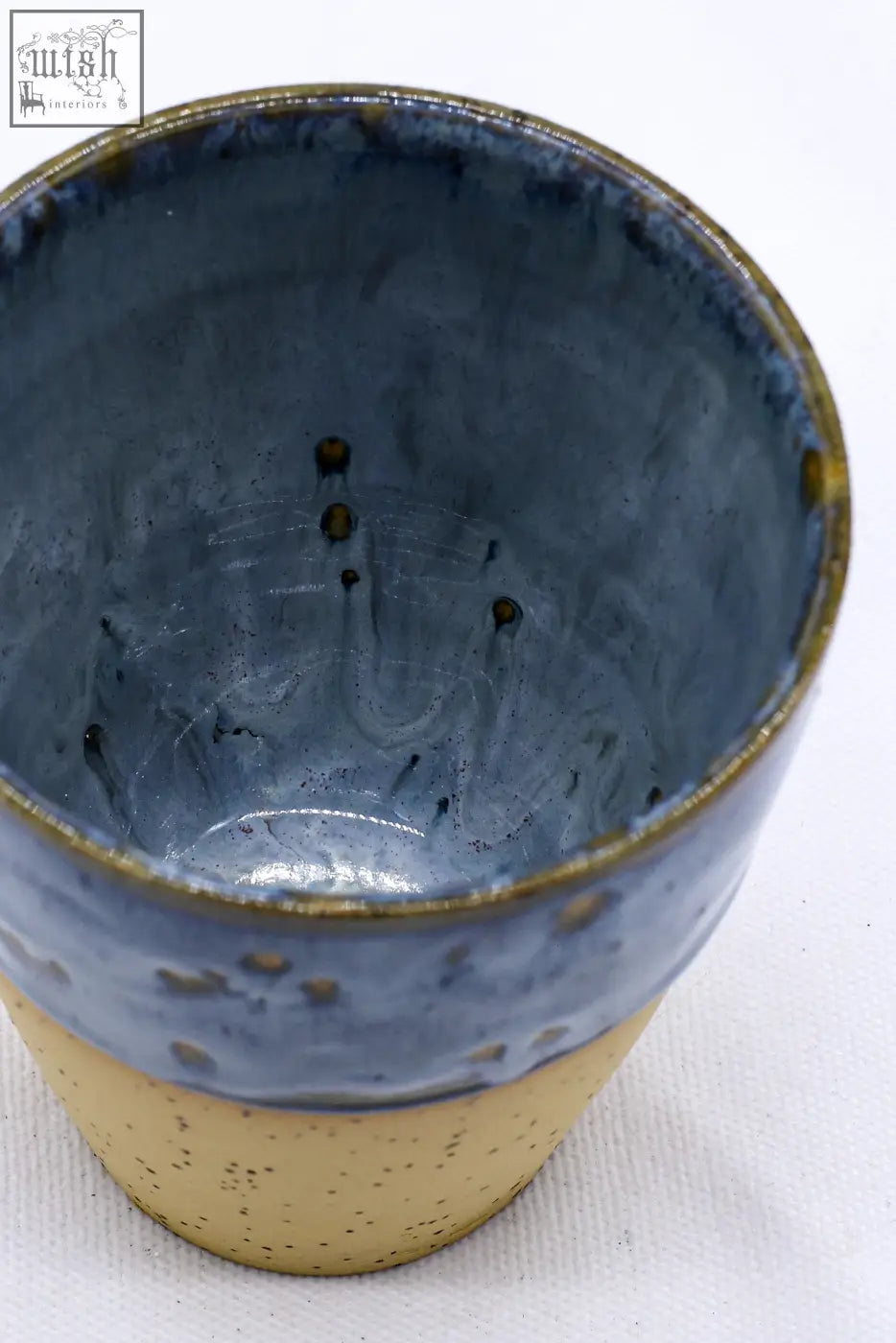 A handcrafted bluvio quadra stoneware ceramic mug with deep blue and speckled beige glaze and gold rim accents