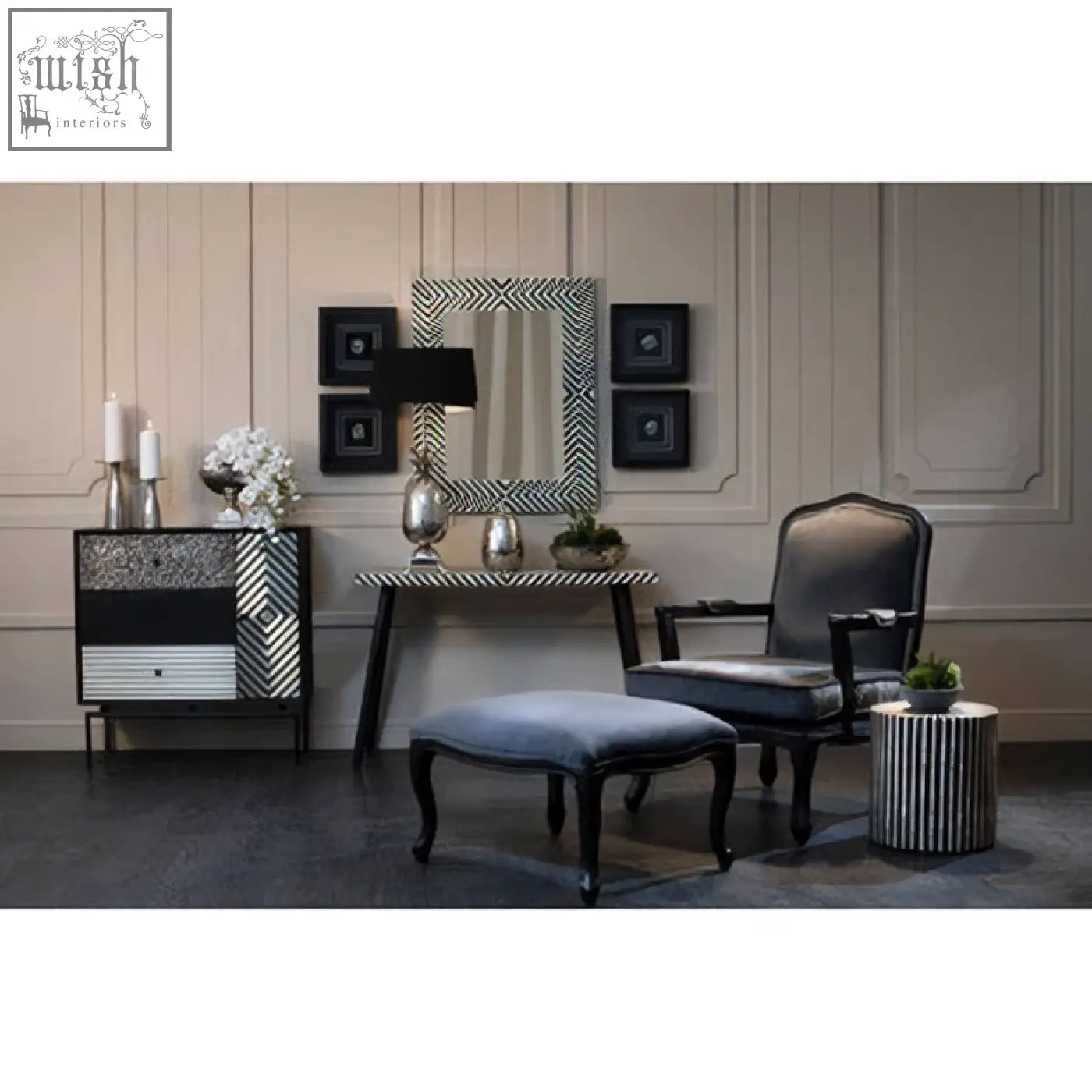 Boho black and white bone inlay console table with metal legs shown next to a black upholstered armchair with ornate wooden frame