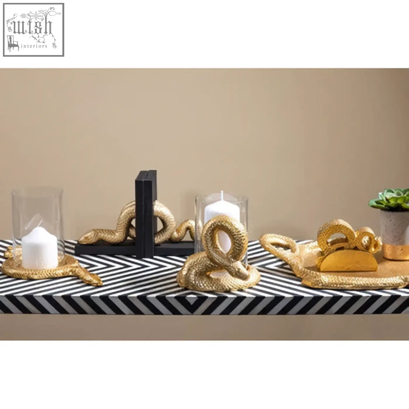 Gold-colored rope coiled snake bookends with braided texture paired with boho black and white bone inlay console table