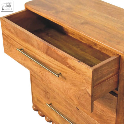 A warm-toned wooden bola three drawer chest with brass handles and rounded feet perfect for bedroom storage